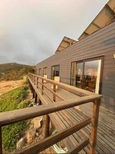 eine Holzbank auf einem Deck neben einem Haus in der Unterkunft Exclusiva casa con hermosa vista in Los Molles