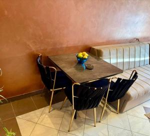 a table with chairs and a couch with a bowl of fruit on it at Apartman Studio Novi in Savina +1 photo