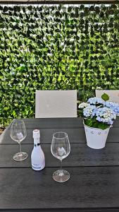 a table with two wine glasses and a bottle on it at Relax Tiny House Ljubljana in Ljubljana