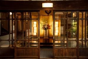 a room with a glass door with a vase of flowers at Hakone Kowakien Mikawaya Ryokan in Hakone