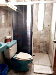 a bathroom with a blue toilet and a shower at Depa 21, Torre Belén, Mazatlán in Mazatlán