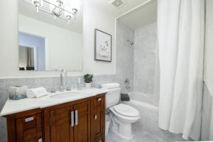 a bathroom with a toilet and a sink and a tub at Stylish & Sunny With Heated Pool In The Foothills! in Phoenix