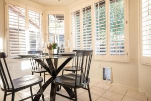 a dining room with a table and chairs and windows at Stylish & Sunny With Heated Pool In The Foothills! in Phoenix