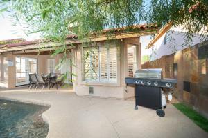 a barbecue grill in front of a house with a pool at Stylish & Sunny With Heated Pool In The Foothills! in Phoenix