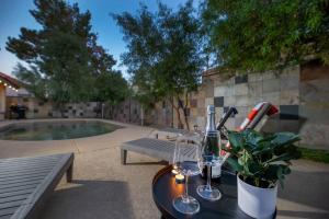 a table with a bottle of wine and a plant at Stylish & Sunny With Heated Pool In The Foothills! in Phoenix