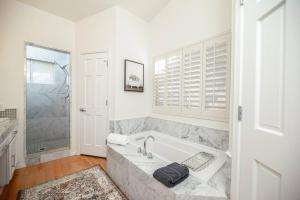 a white bathroom with a tub and a window at Stylish & Sunny With Heated Pool In The Foothills! in Phoenix