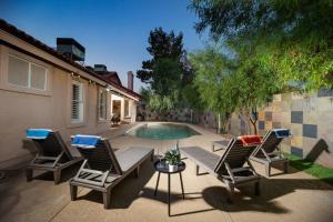 a patio with chairs and a table and a pool at Stylish & Sunny With Heated Pool In The Foothills! in Phoenix