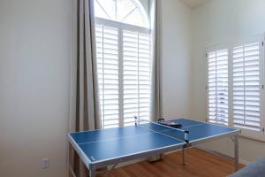 a blue ping pong table in front of a window at Stylish & Sunny With Heated Pool In The Foothills! in Phoenix
