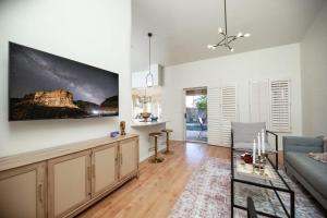 a living room with a couch and a tv on a wall at Stylish & Sunny With Heated Pool In The Foothills! in Phoenix