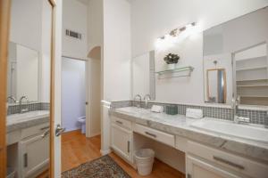 a bathroom with two sinks and a large mirror at Stylish & Sunny With Heated Pool In The Foothills! in Phoenix