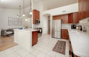 a kitchen with wooden cabinets and a white counter top at Stylish & Sunny With Heated Pool In The Foothills! in Phoenix