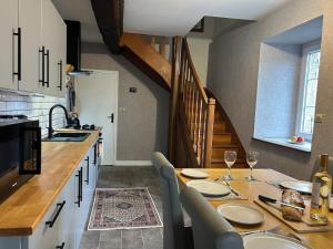 a kitchen with a table with chairs and a sink at Maison de Champeaux in Saint-Fraimbault-sur-Pisse