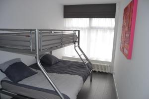 Ce lit superposé se trouve dans un dortoir doté d'une fenêtre. dans l'établissement Au quai 34 appartement, à Boulogne-sur-Mer