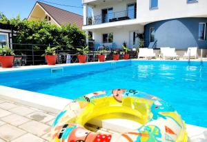 a swimming pool with an inflatable raft in a swimming pool at Vila Toscana in Eforie Nord