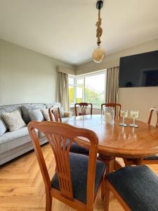 ein Esszimmer mit Tisch und Stühlen und einer Couch in der Unterkunft Harbour Mill Cottage in Annalong