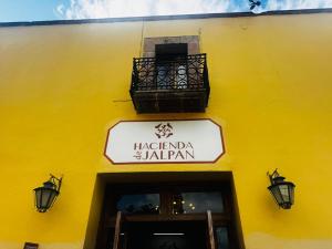 a yellow building with a sign and a balcony at Hacienda de Jalpan in Jalpan