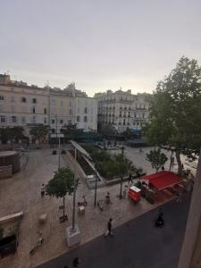 a city square with a red tent and buildings at Le Central Studio in Marseille