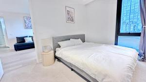 メルボルンにあるHeart CBD White Crystal Residence in Empire Pool n GYMのベッドとソファのある白い寝室