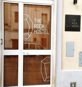 a door to the rock hostel with a sign on it at The Rock Hostel in Matera