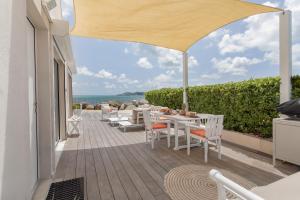 a patio with a table and chairs and an umbrella at Sweet Home sur la plage in Marigot