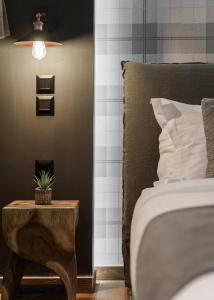 a bedroom with a bed and a table with a plant on it at Leonidas by GM Luxury Suites Kalavryta in Kalavrita