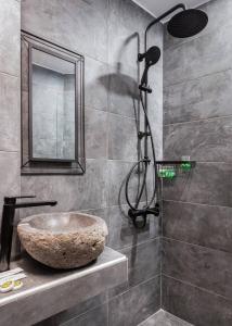 a bathroom with a stone sink and a shower at Leonidas by GM Luxury Suites Kalavryta in Kalavrita