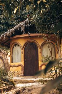 ein kleines Haus mit einer Tür in einem Wald in der Unterkunft Sol de Minca Eco Lodge in Minca