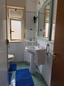 a bathroom with a sink and a toilet and a mirror at D Amuri Sea Home in Siracusa +32 photos