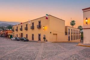 ein großes Gebäude mit auf einem Parkplatz abgestellten Autos in der Unterkunft Hacienda de Jalpan in Jalpan de Serra
