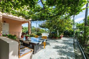 a patio with a table and chairs and trees at Zotos Rooms in Parga