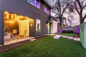 a backyard with a house with a lawn and lights at Electric Disco Den - 6 Min Walk to Rainey St in Austin