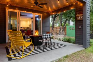a screened porch with yellow chairs and a table at Electric Disco Den - 6 Min Walk to Rainey St in Austin