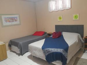 a room with two beds in a room at Lopez Village GuestHouse in Serra Negra