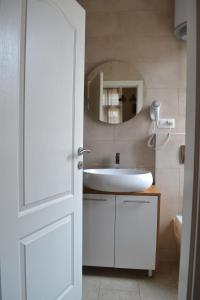 a bathroom with a white sink and a mirror at Narona 1910 apartments in Mostar