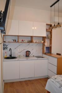 a kitchen with white cabinets and a sink at Narona 1910 apartments in Mostar