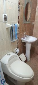a bathroom with a white toilet and a sink at WaskarWasi in Cusco