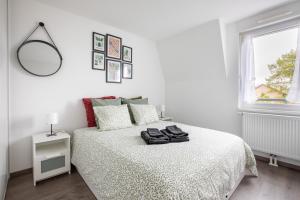 a white bedroom with a bed and a window at The Bright Urban Calm Basel St Louis in Saint-Louis