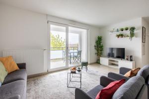 a living room with a couch and a tv at The Bright Urban Calm Basel St Louis in Saint-Louis