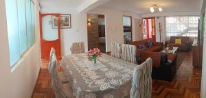 a dining room with a table with a vase of flowers on it at WaskarWasi in Cusco +28 photos