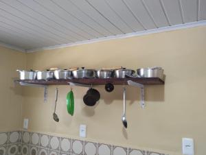 a shelf with pots and pans on a wall at Individual cama in Ouro Preto