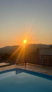a view of the sun setting over a swimming pool at Chácara Bella Vista Mairinque in Mairinque