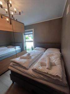 a bedroom with a large bed with white sheets at Villa Varden 10 min from Bergen sentrum in Bergen