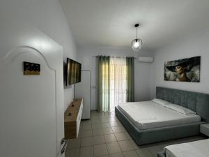 a bedroom with a bed and a desk in it at Zhiti Waves in Durrës