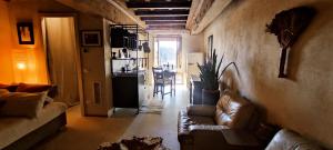 a living room with a couch and a kitchen at Eifù - Un antico nido ritrovato in Robecco sul Naviglio