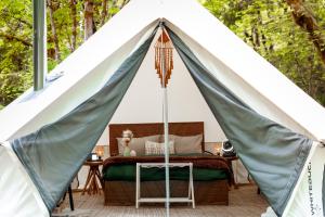 a canopy tent with a bed and a table at Creekside Retreat at Triangle Lake in Blachly