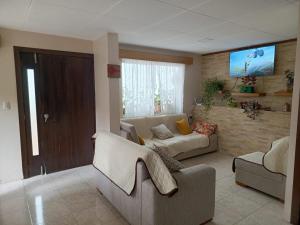 a living room with a couch and a tv at Grandma's house in Cuenca