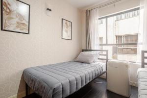 Un dormitorio pequeño con una cama y una ventana. en Interior con estilo y accesible, en Ciudad de México
