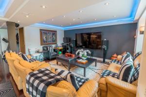 a living room with couches and a tv at Richmond Hill Ravine Retreat in Richmond Hill +18 photos