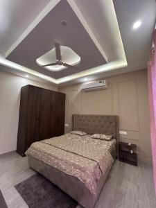 a bedroom with a bed and a ceiling at Beauty Living in Kharar