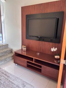 a flat screen tv sitting on top of a wooden entertainment center at Casa Refúgio Canto da Viola in São Roque